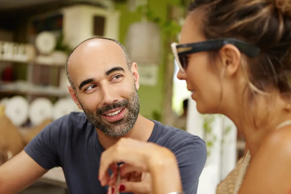 Pessoa sorrindo e mantendo contato visual, indicando interesse
