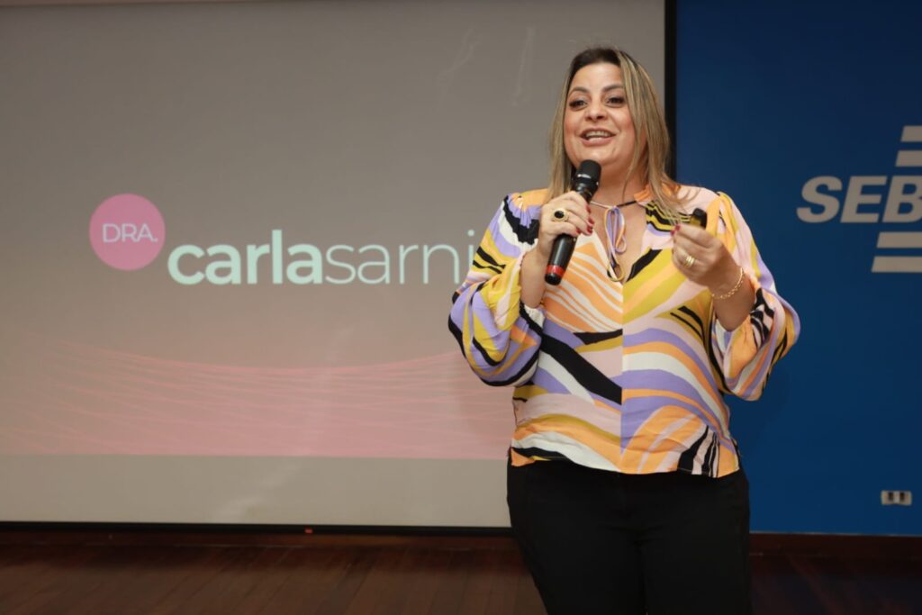 Carla Sarni em frente a uma clínica Sorridents, representando o sucesso na odontologia acessível no Brasil.