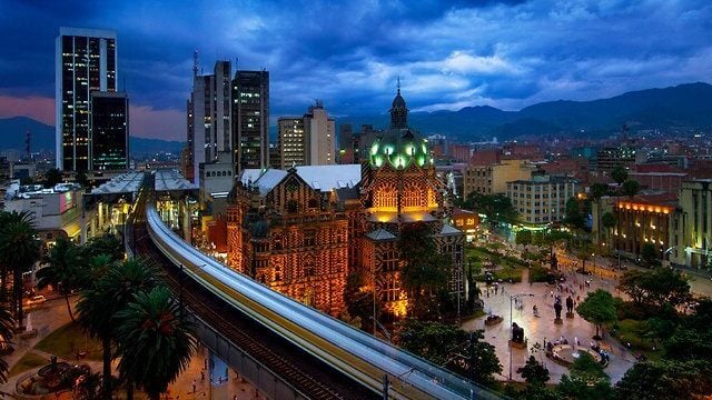 Centro histórico de Medellín com arquitetura colorida e montanhas ao fundo, atraente para quem considera uma mudança de país com economia.